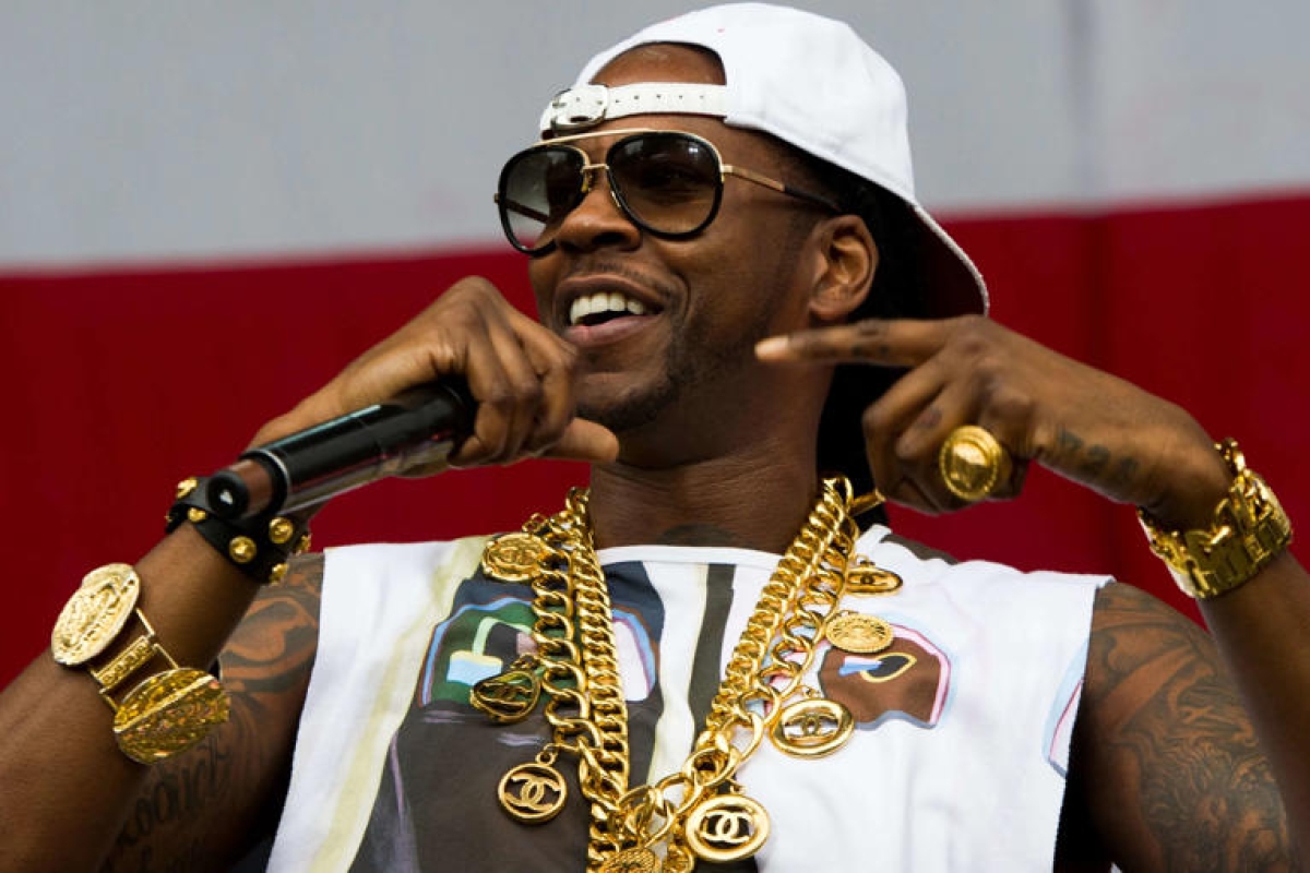 Rapper 2 Chainz grabs attention courtside in a custom Atlanta jacket during the Bucks vs. Hawks NBA Cup showdown.